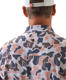Man wearing a vintage camo patterned short-sleeve button down shirt on a white background