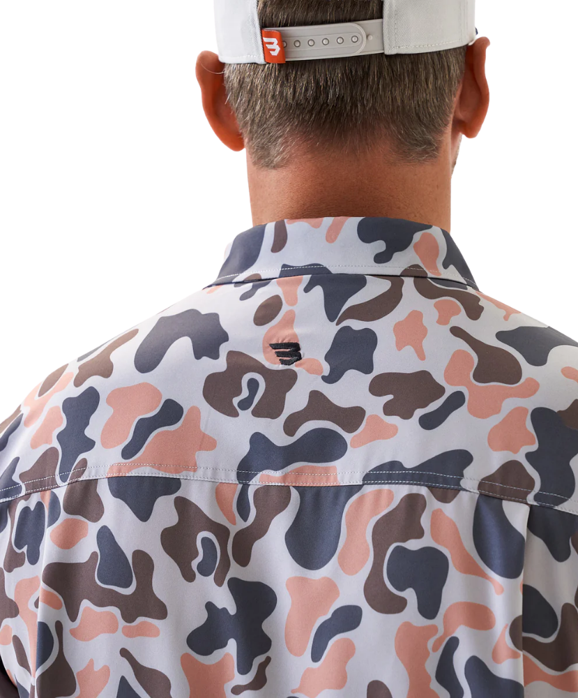 Man wearing a vintage camo patterned short-sleeve button down shirt on a white background