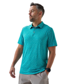 Man wearing a teal golf club and golf ball  dot polo shirt on a white background