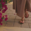 Beige OLUKAI sandal with a strap on a white background