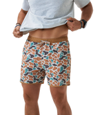 Person wearing CAMO patterned swim shorts on a white background