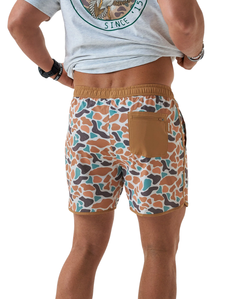 Person wearing CAMO patterned swim shorts on a white background
