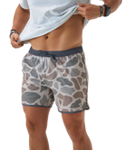 Person wearing camouflage SWIM shorts on a white background