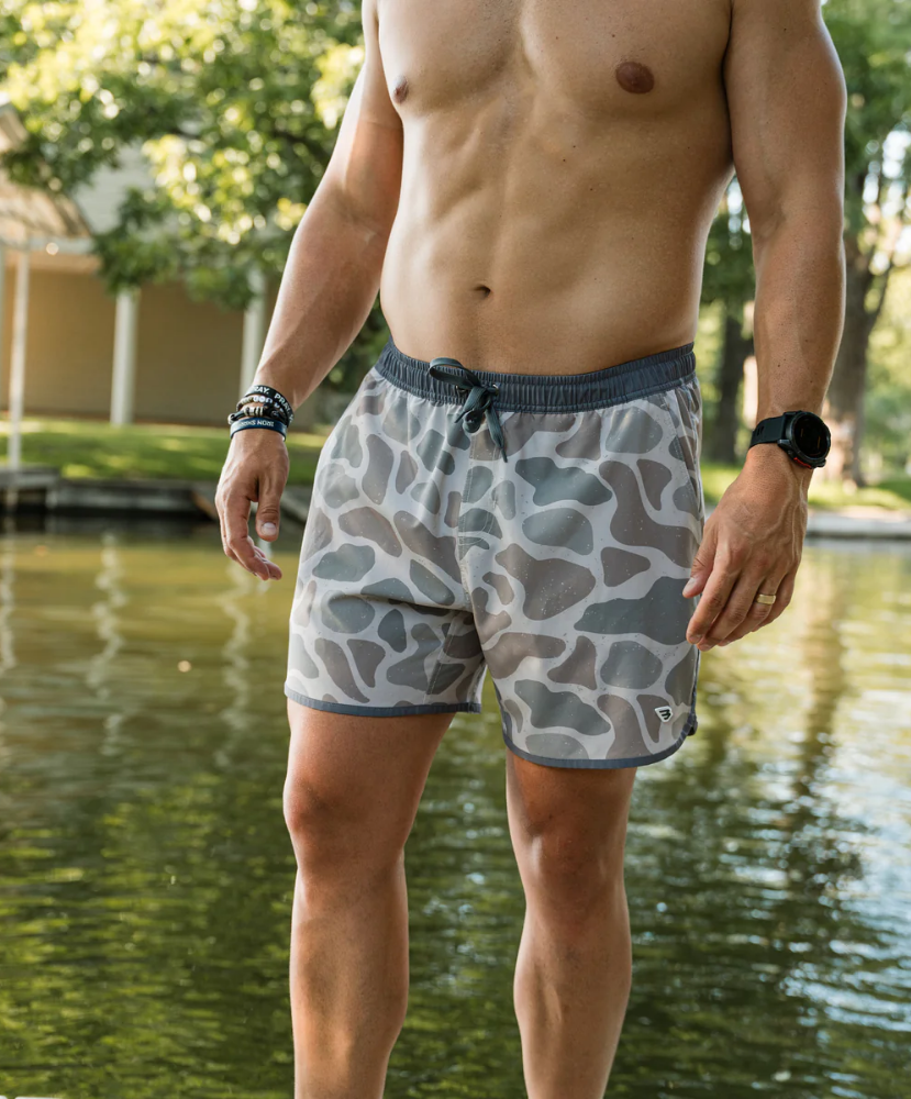 Person wearing camouflage SWIM shorts on a white background