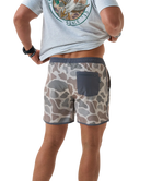 Person wearing camouflage SWIM shorts on a white background
