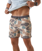 Person wearing camouflage swim shorts on a white background