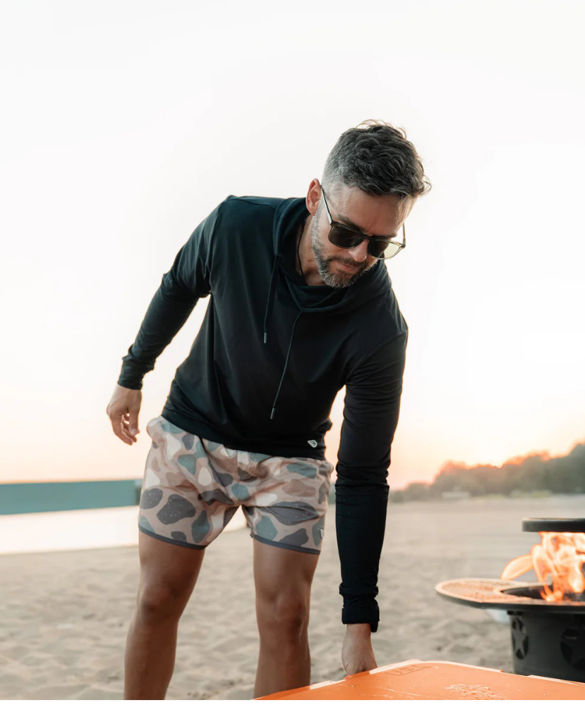 Person wearing camouflage swim shorts on a white background