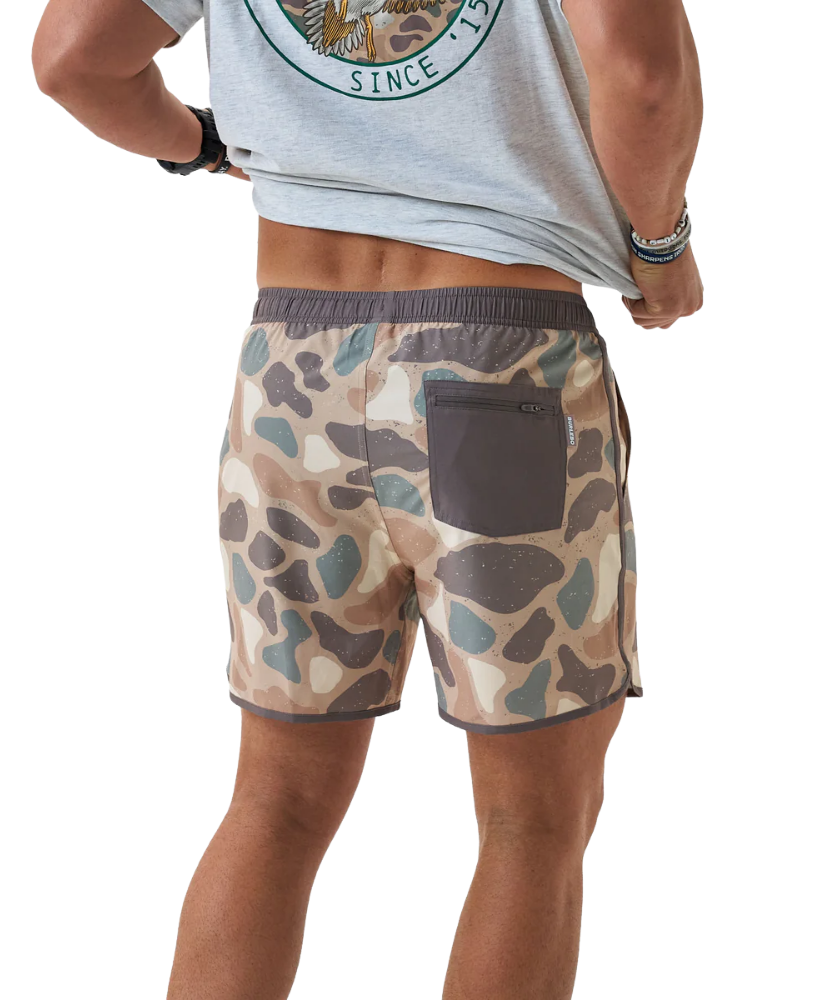 Person wearing camouflage swim shorts on a white background