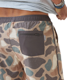 Camouflage-patterned swim shorts with a pocket and visible brand logo.
