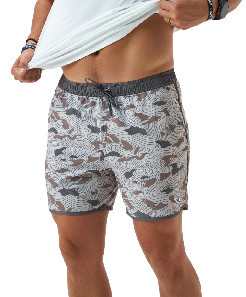 Person wearing camouflage swim shorts on a white background