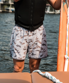 Person wearing camouflage swim shorts on a white background