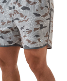 Person wearing camouflage swim shorts on a white background