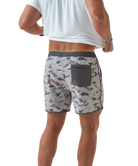 Person wearing camouflage swim shorts on a white background