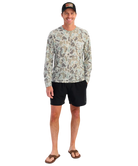 Man wearing a camouflage long-sleeve shirt and black shorts on a white background