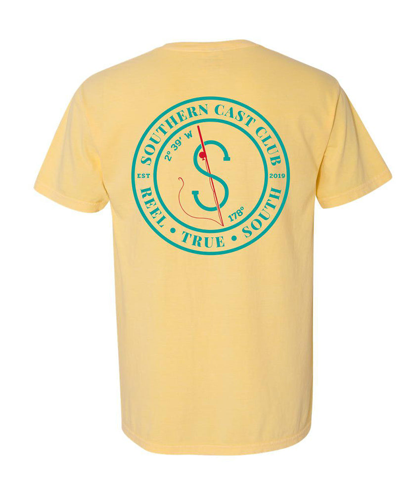 A pale yellow short-sleeve t-shirt shown from the back, featuring a large teal circular graphic with a compass and the words 'SOUTHERN CAST CLUB' and 'KELLY • TRUE • SOUTH'.